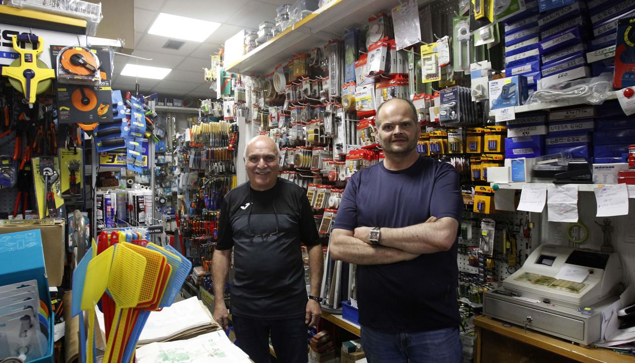 El dueño de la ferretería Marconi, Óscar Naya, y su empleado, posan dentro del negocio