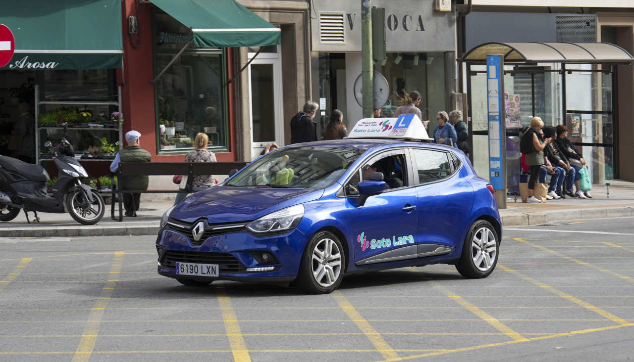 Un coche de autoescuela, ayer, a su paso por la ronda de Outeiro