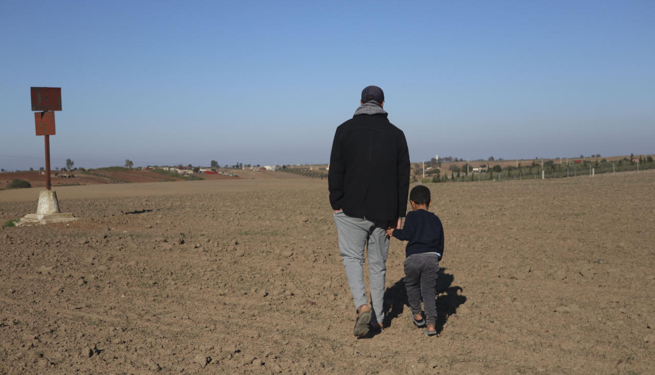 Un hombre y su hijo caminan por un campo seco de trigo en Rabat