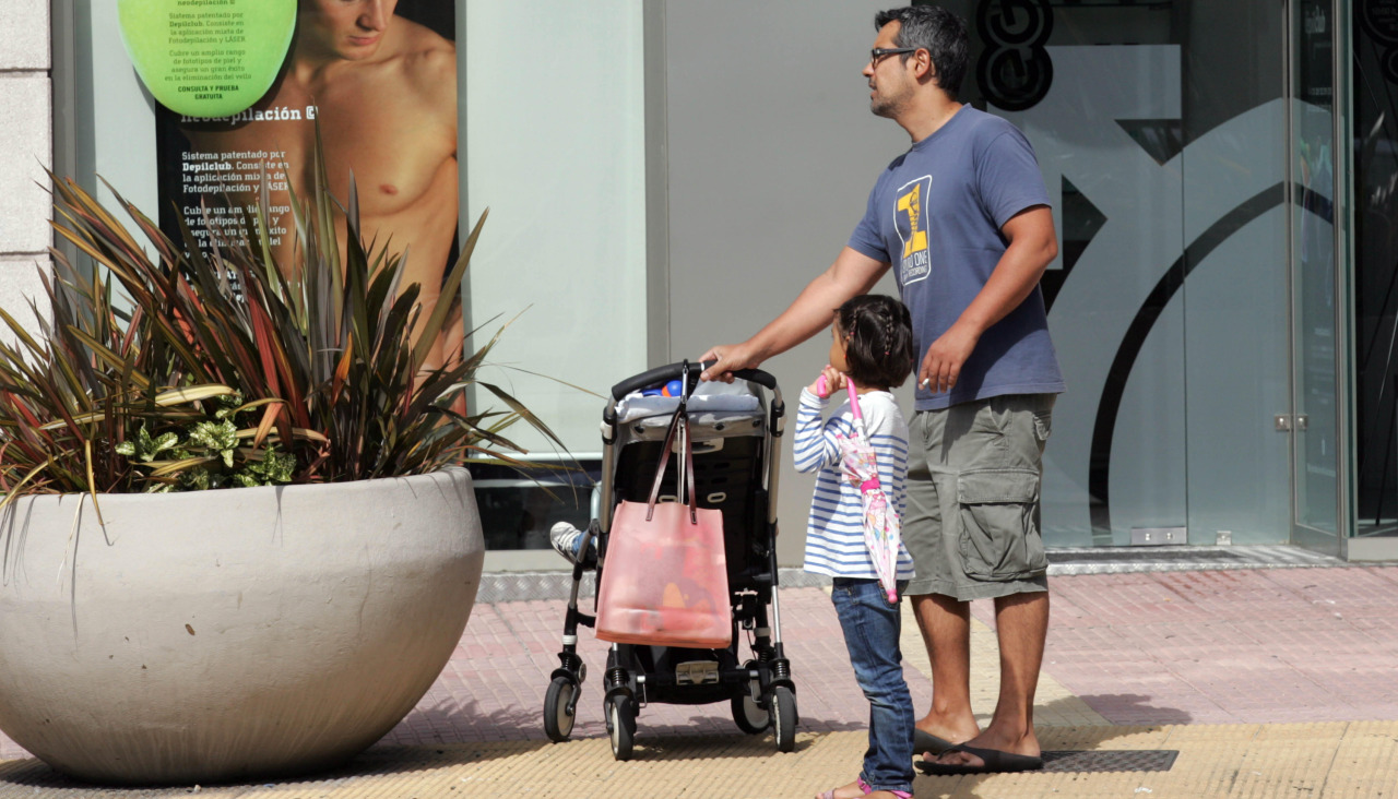 Un hombre cuida a dos niños en una calle