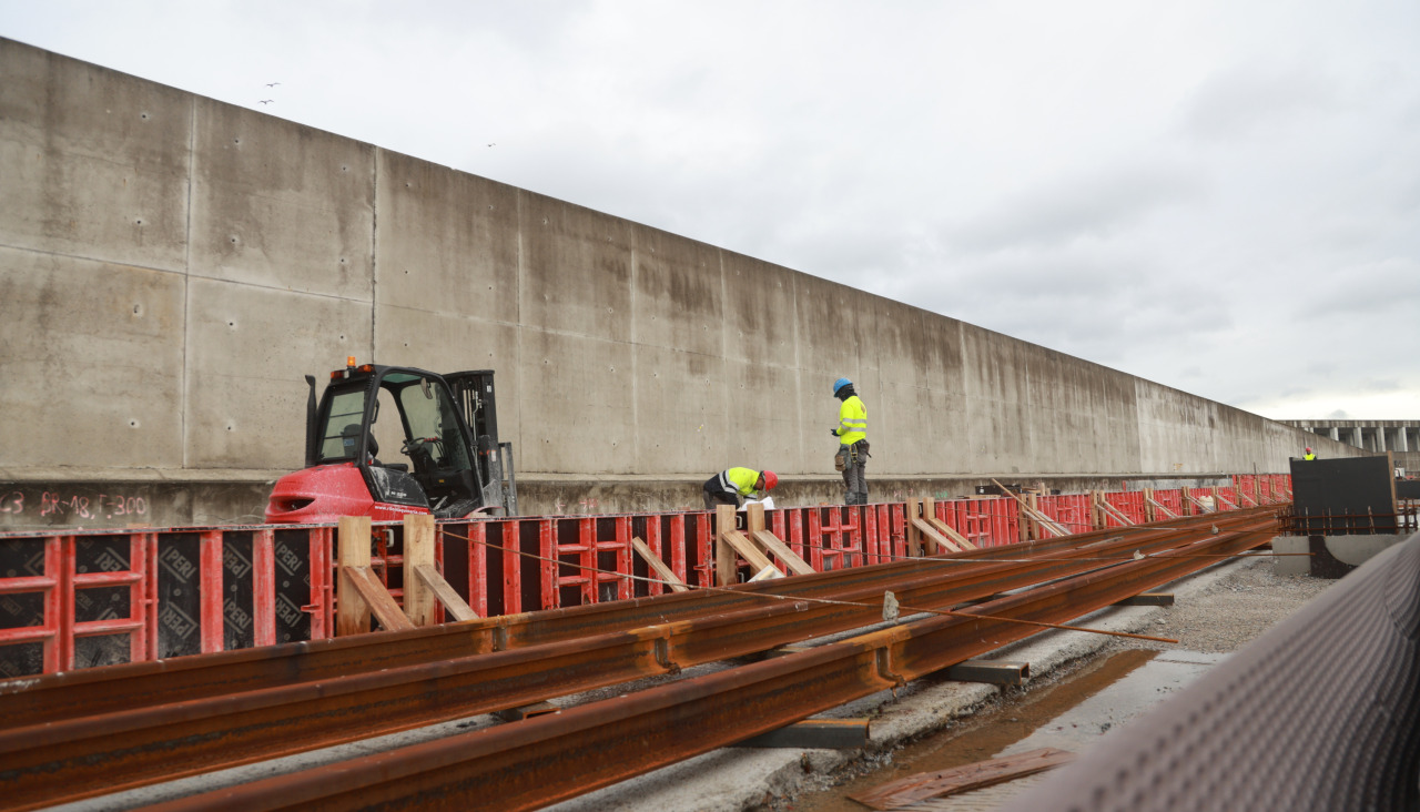 Operarios trabajan, ayer, en la colocación de los raíles de la red ferroviaria de la dársena de Langosteira