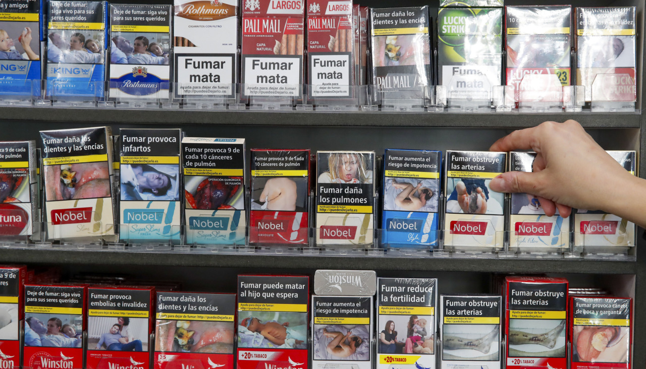 Una persona toma una cajetilla de tabaco en un estanco