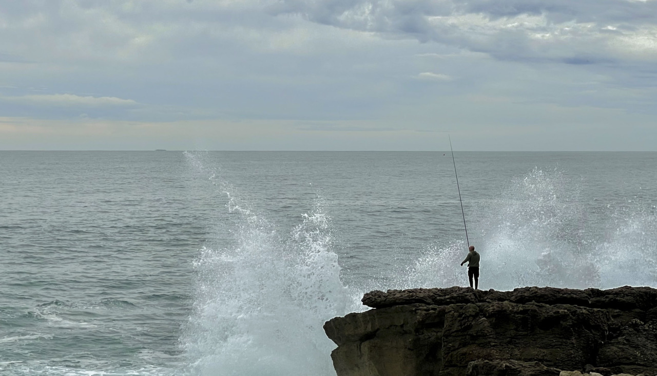 Unha persoa pesca nun día de temporal