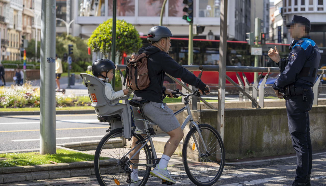 Un policía local aborda a un ciclista para informarle
