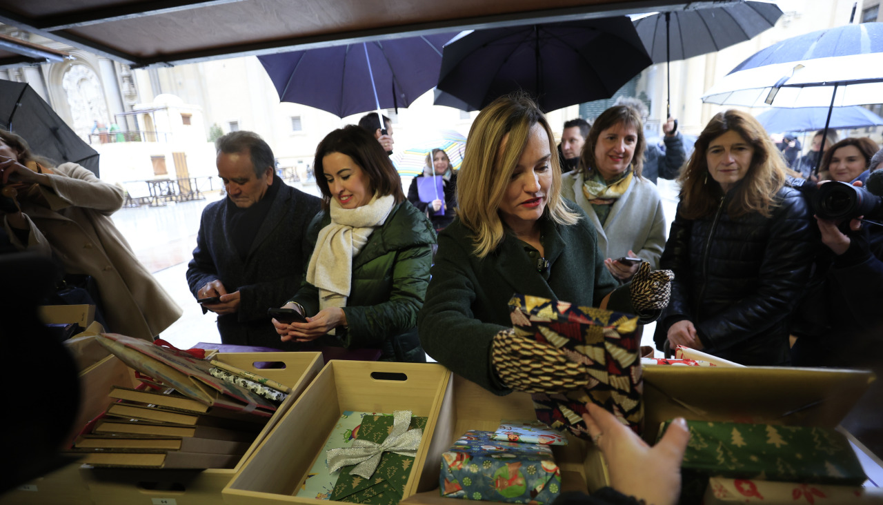 Pilar Alegría intercambia un libro en la plaza del Pilar