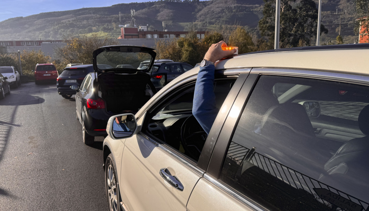 Un conductor coloca una baliza de emergencia tras un accidente
