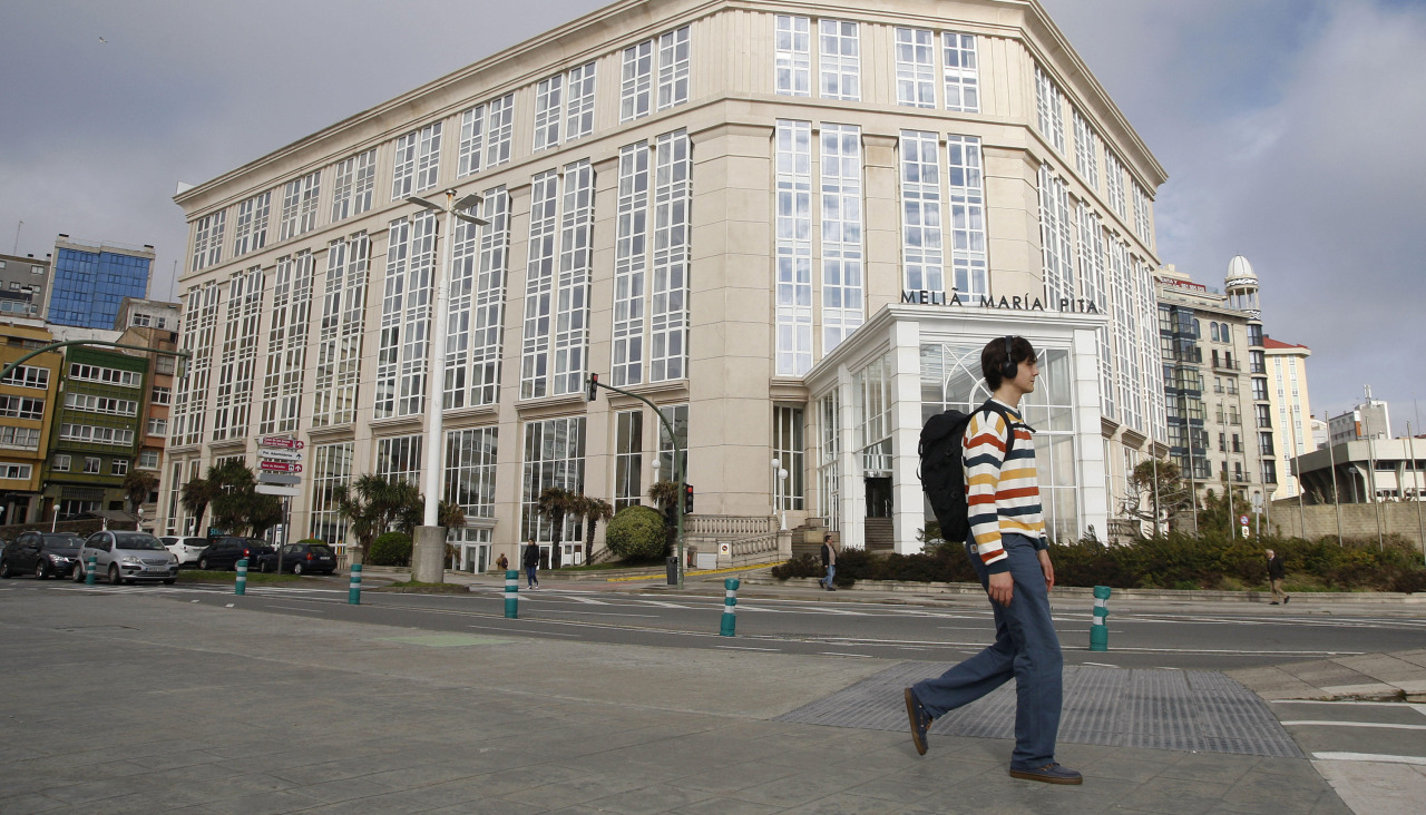Un hombre camina frente al Meliá María Pita