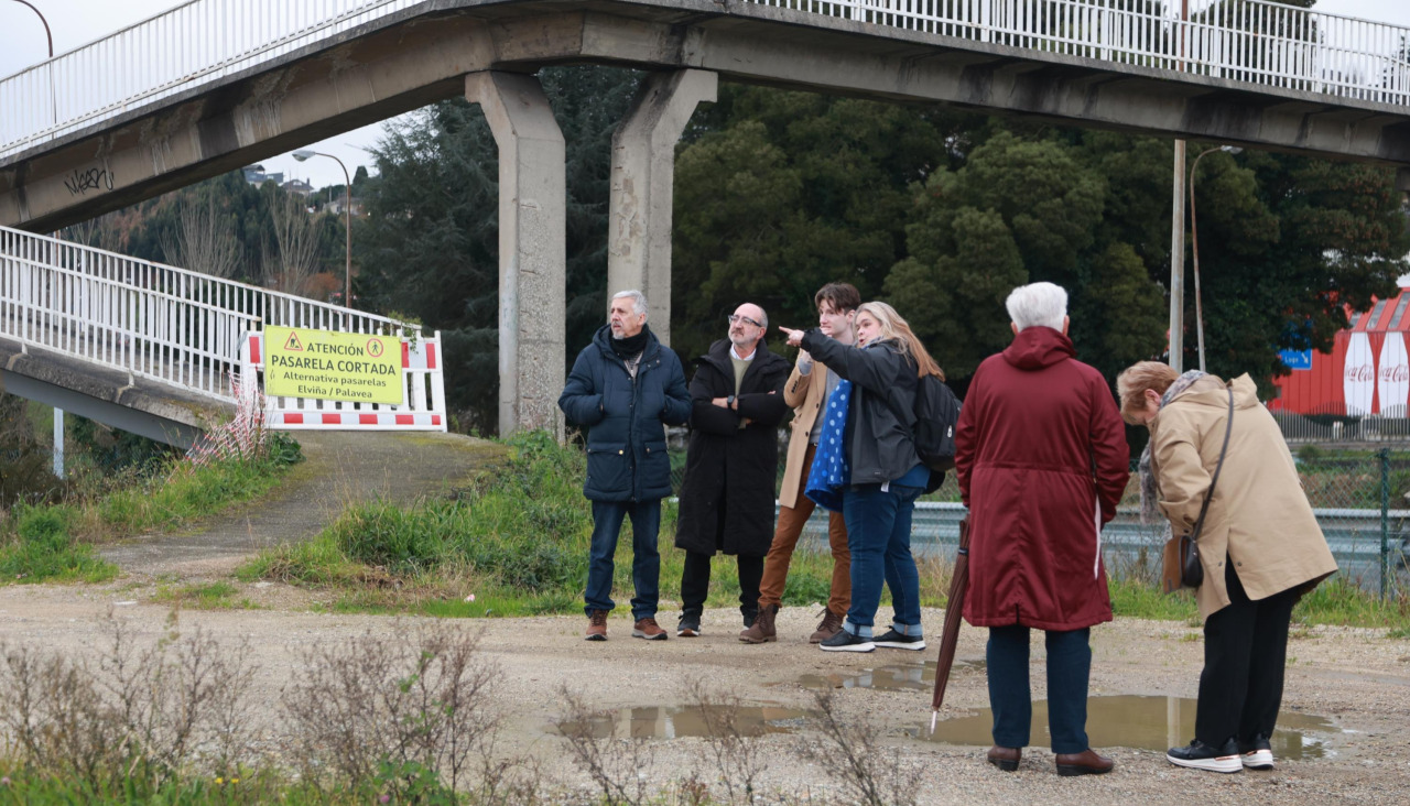Los representantes de las asociaciones vecinales, ayer por la tarde, junto a la pasarela cerrada en Alfonso Molina |