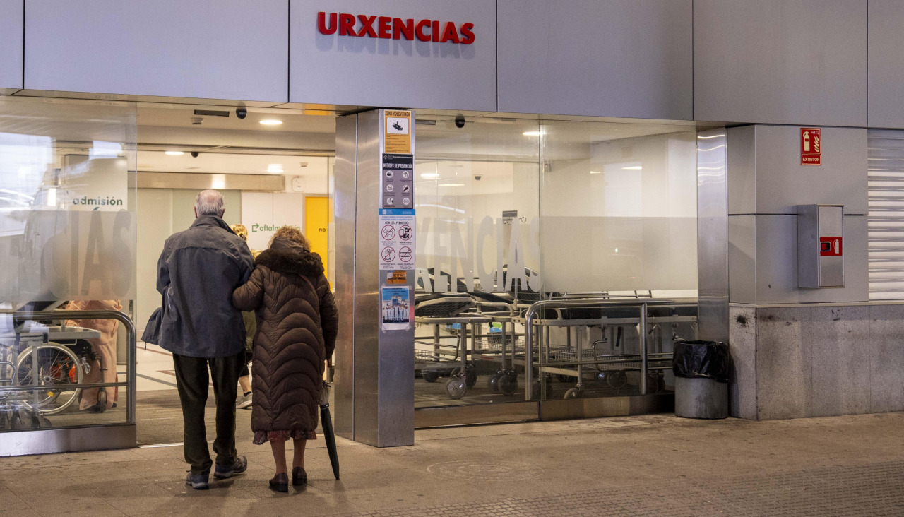 Dos personas en la entrada de Urgencias del Chuac