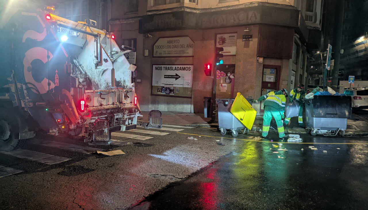 Operarios de la empresa de recogida de basura retirando restos esparcidos en el cruce de la calle Juan Flórez con Marcial del Ad