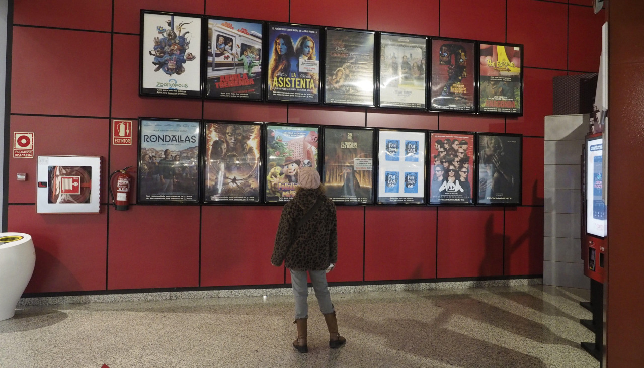 Una espectadora mira la cartelera de los Odeón Multicines de Narón