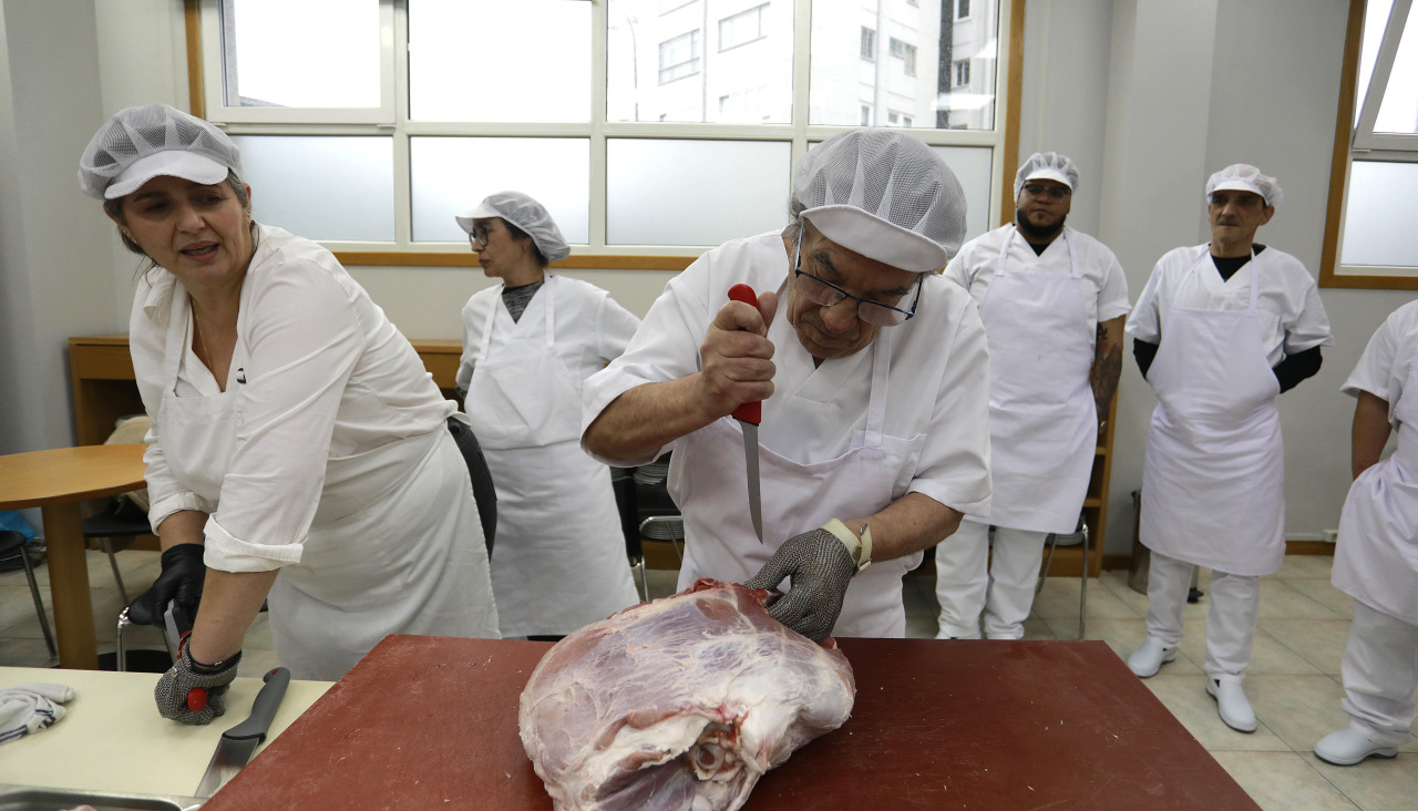 Un alumno manipula, este miércoles, una pieza de carne ante la supervisión de su profesora 