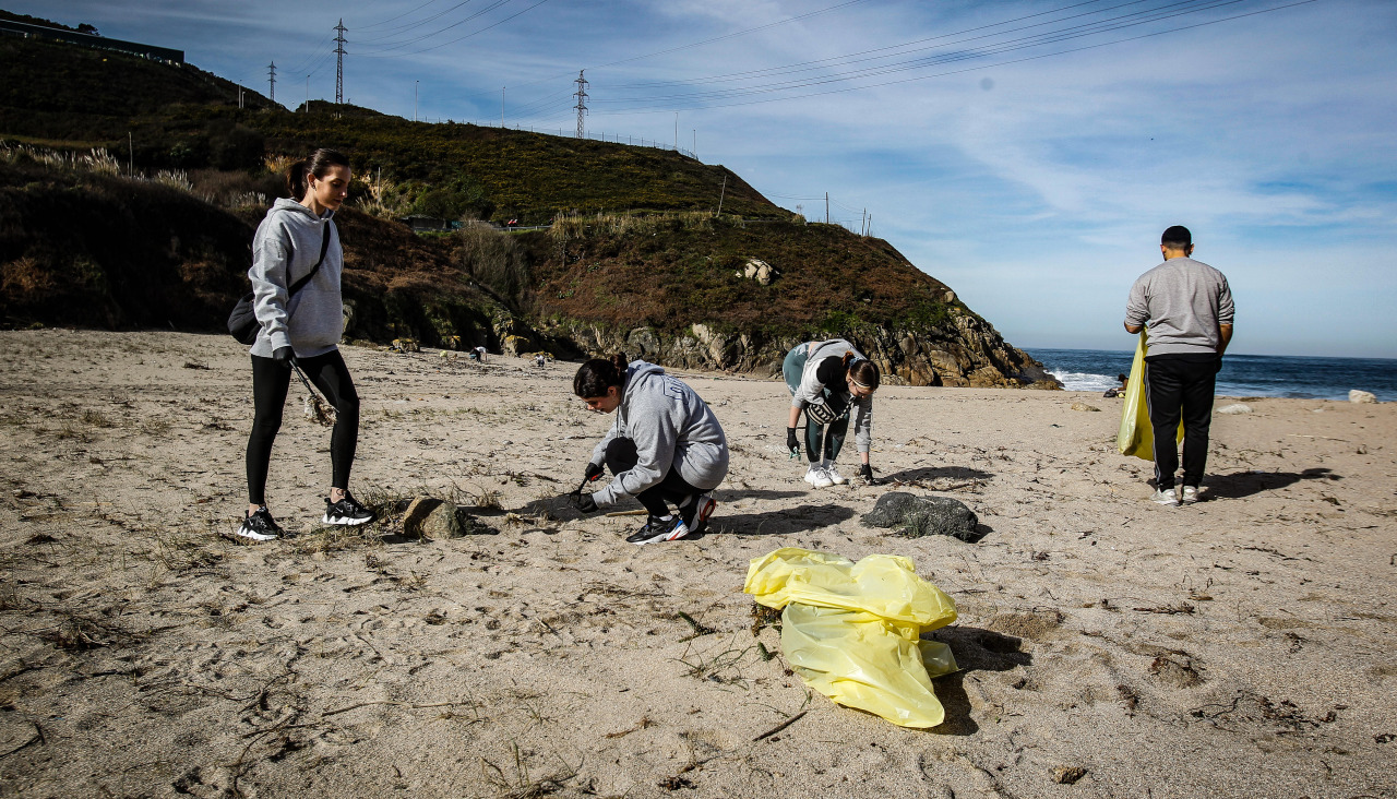 Varias personas limpiando la playa de Bens