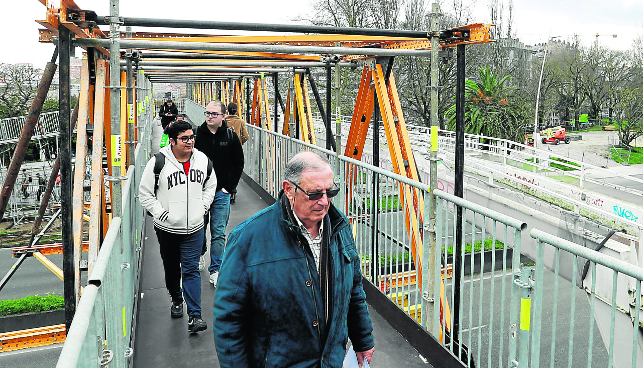 Varias personas cruzan por la pasarela provisional entre las estaciones
