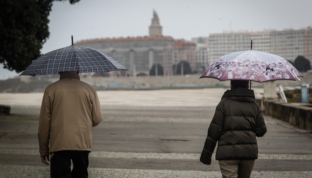 Dos personas pasean bajo la lluvia, ayer, en la zona de las Esclavas