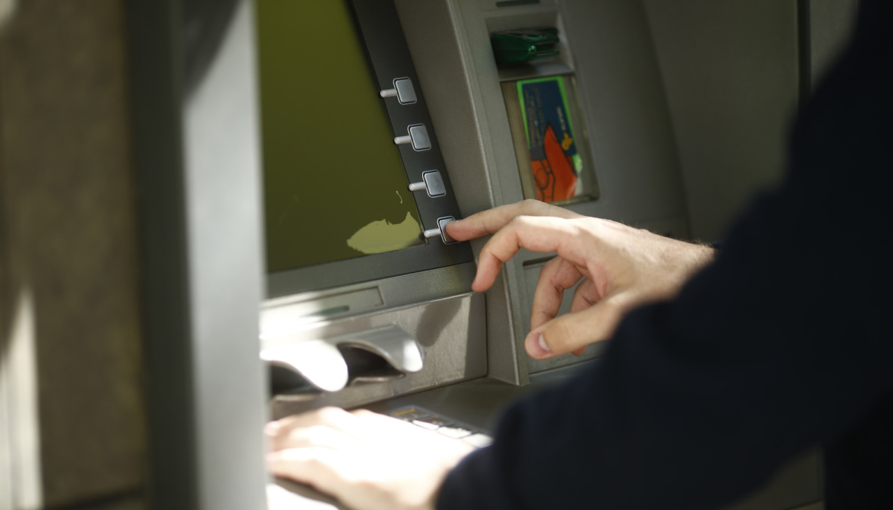 Unha persoa consulta os seus movementos bancarios nun caixeiro