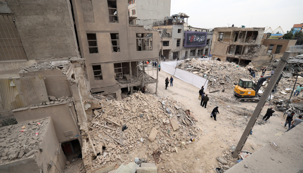 TEHRAN (Iran (Islamic Republic Of)), 15/03/2026.- Iranians walk amid damaged residential buildings in southern Tehran, Iran, 15 March 2026. A joint Israeli and US military operation continues to target multiple locations across Iran since the early hours of 28 February 2026. (Teherán) EFE/EPA/ABEDIN TAHERKENAREH