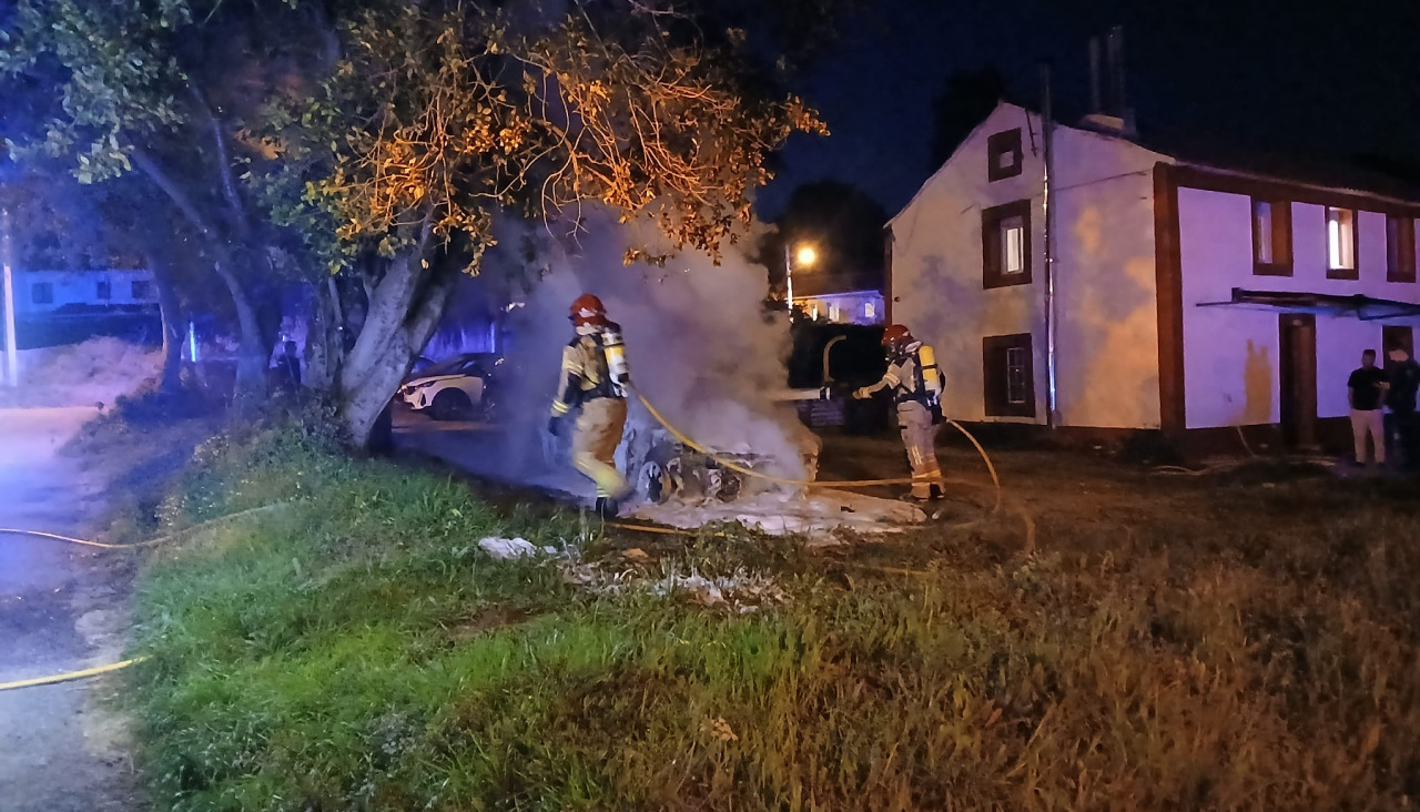 Los Bomberos de Oleiros apagan el coche incendiado en Liáns