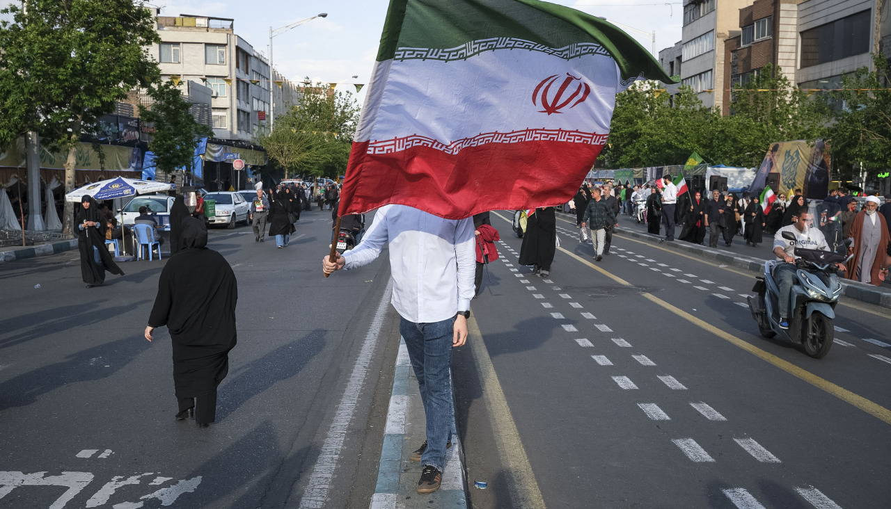Un hombre ondea una bandera de la República Islámica en un acto en Teherán de apoyo al líder líder supremo, Mojtaba Jameneí