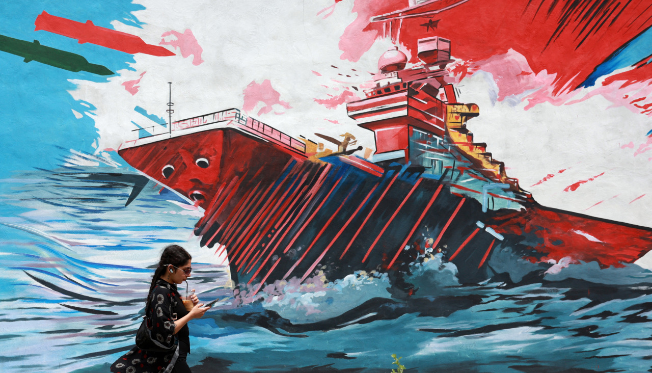 Una mujer iraní camina junto a un mural antiestadounidense en una calle de Teherán, este lunes