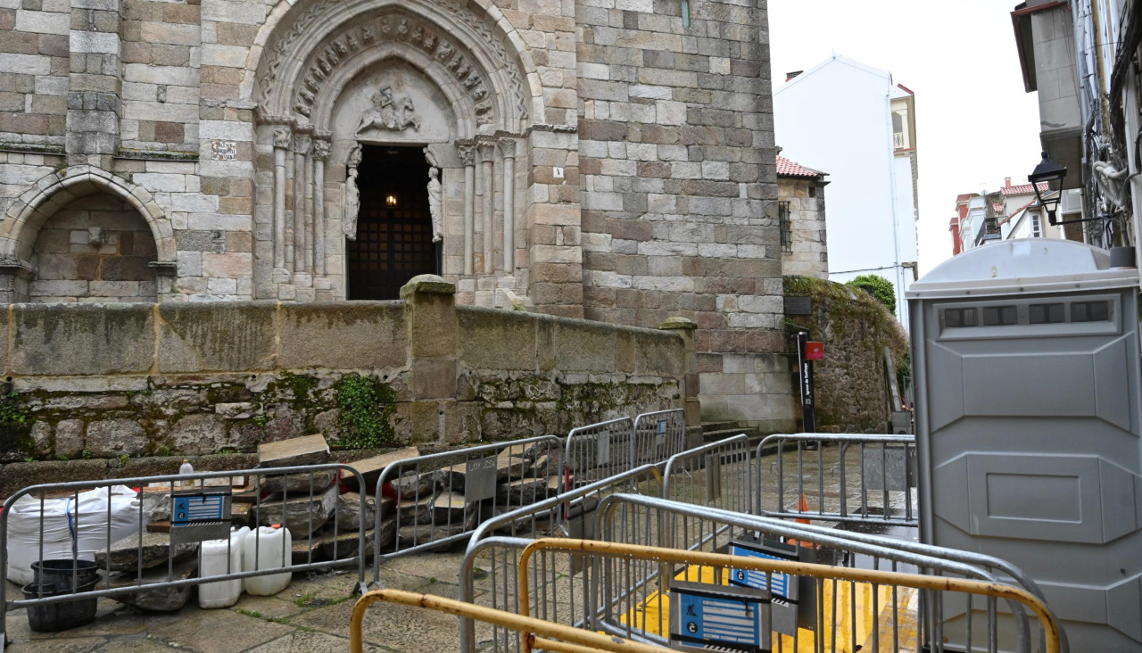 Obras paralizadas en la calle de O Parrote, con la placa amarilla que cubre la tumba, abajo a la derecha