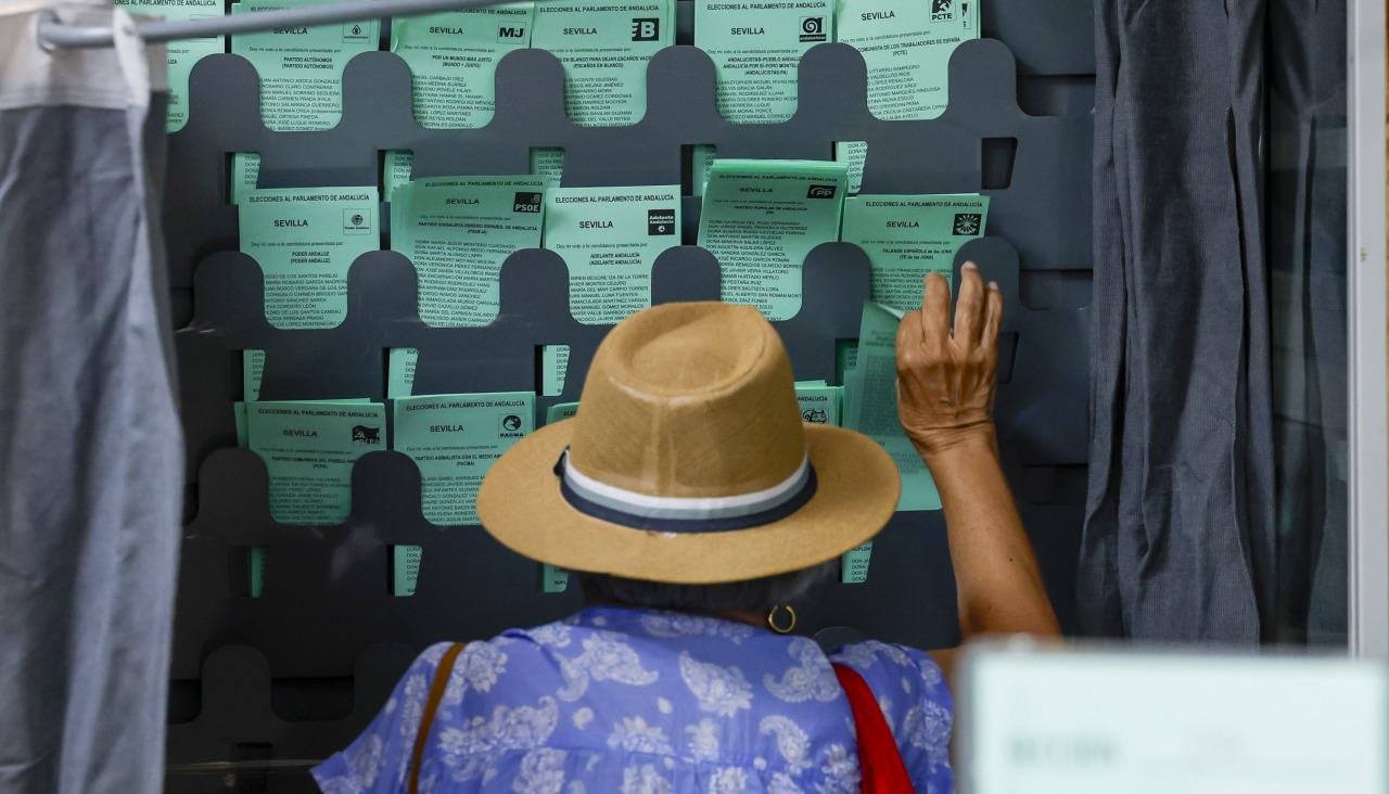Una mujer ejerce su derecho al voto en un colegio electoral en Sevilla