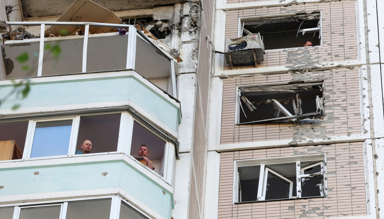Varias personas inspeccionan los daños en un edificio atacado en Moscú