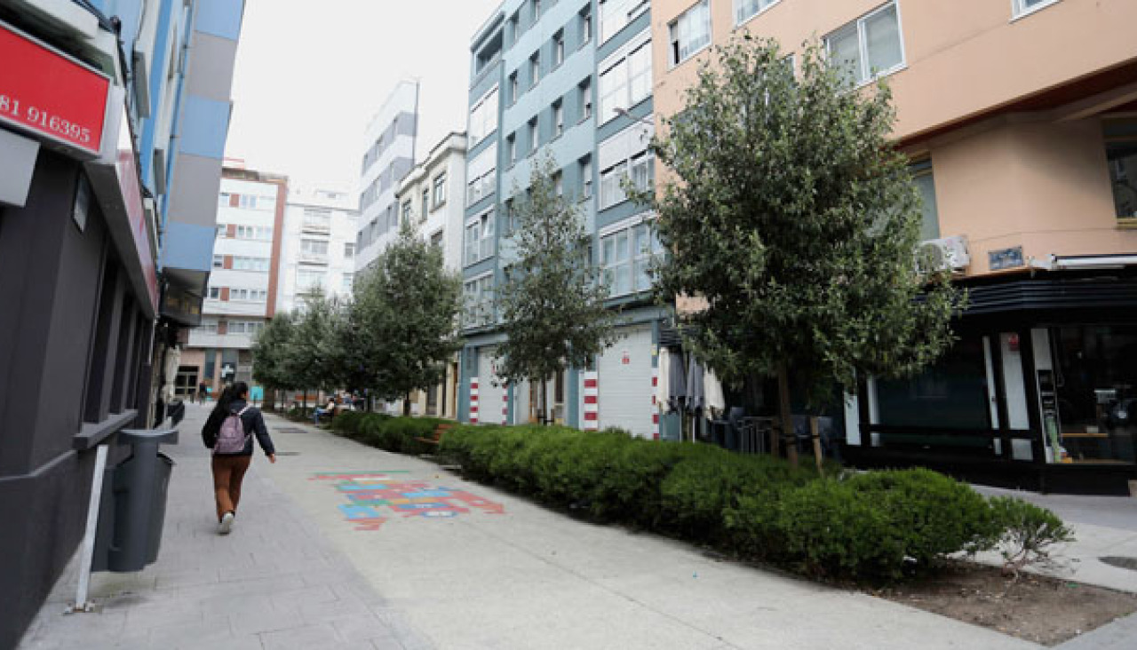 Una transeúnte recorre la pequeña calle San Leopoldo (peatonalizada en 2022), en el Agra do Orzán, uno de los barrios de la ciudad con más necesidad de zonas verdes
