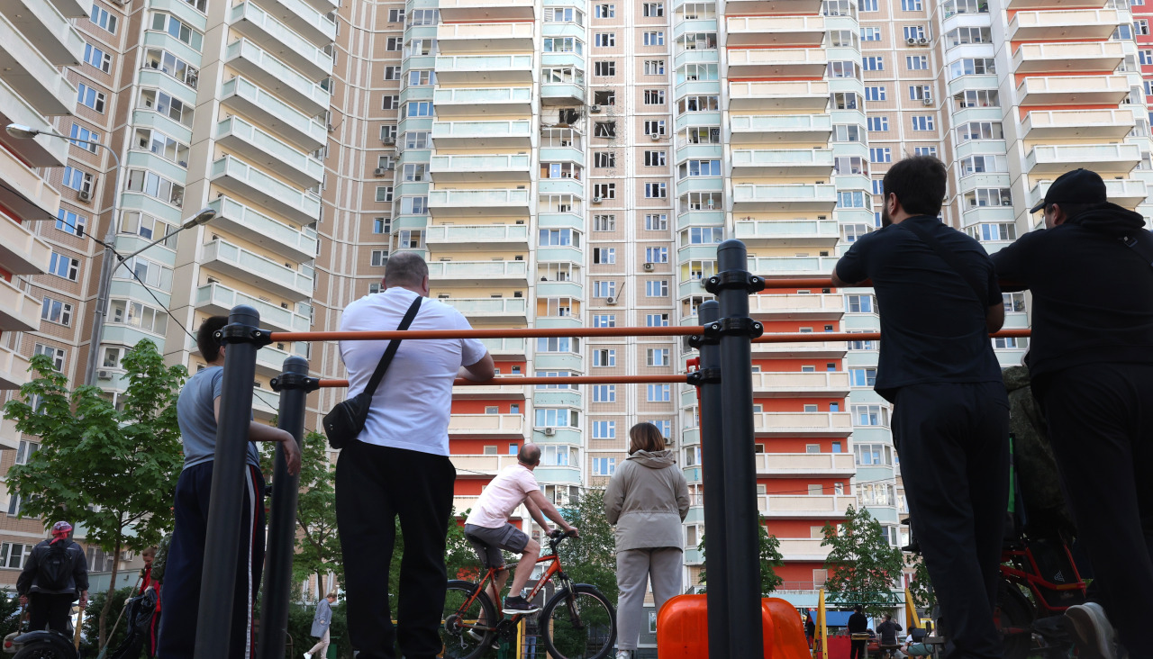 Varias personas contemplan un edificio alcanzado por los ataques ucranianos en Moscú