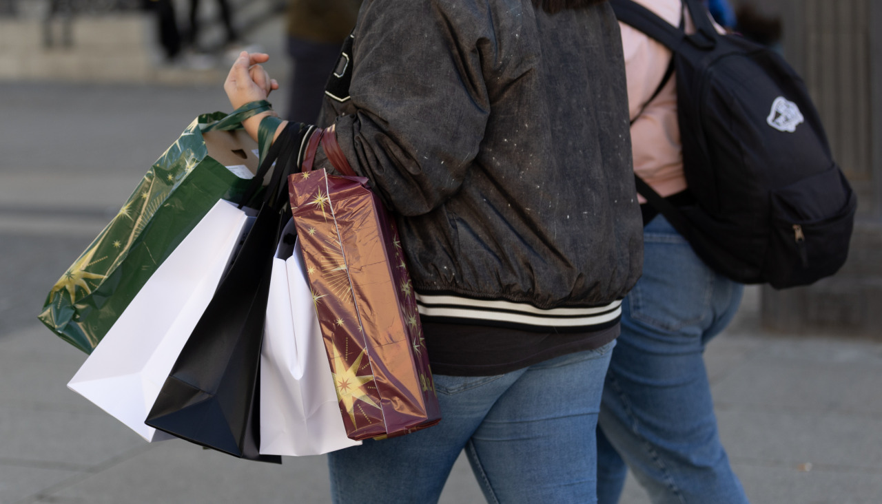 Dúas persoas cargan bolsas tras realizar varias compras
