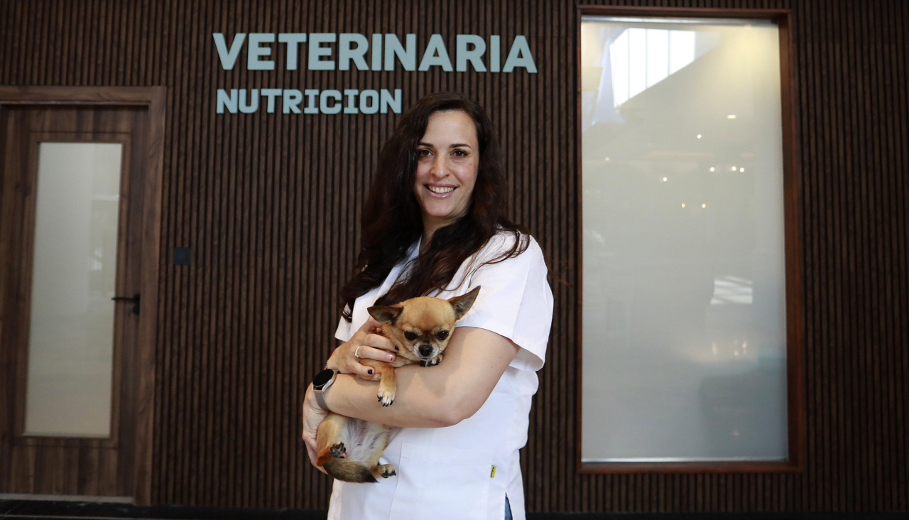 Ángela Vela posa con su perro delante de la clínica Avela Nutrición Veterinaria