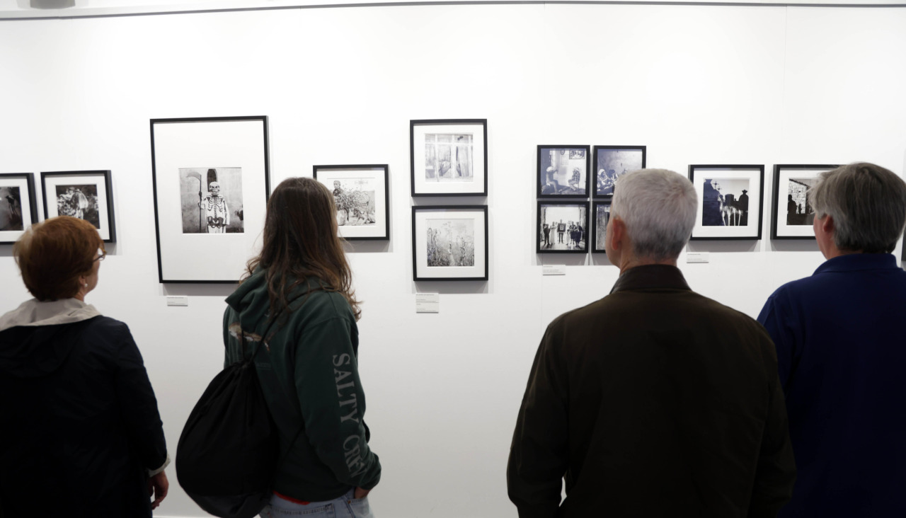 Varias personas ven imaxes da exposición 'Viaxe ao Mictlán'