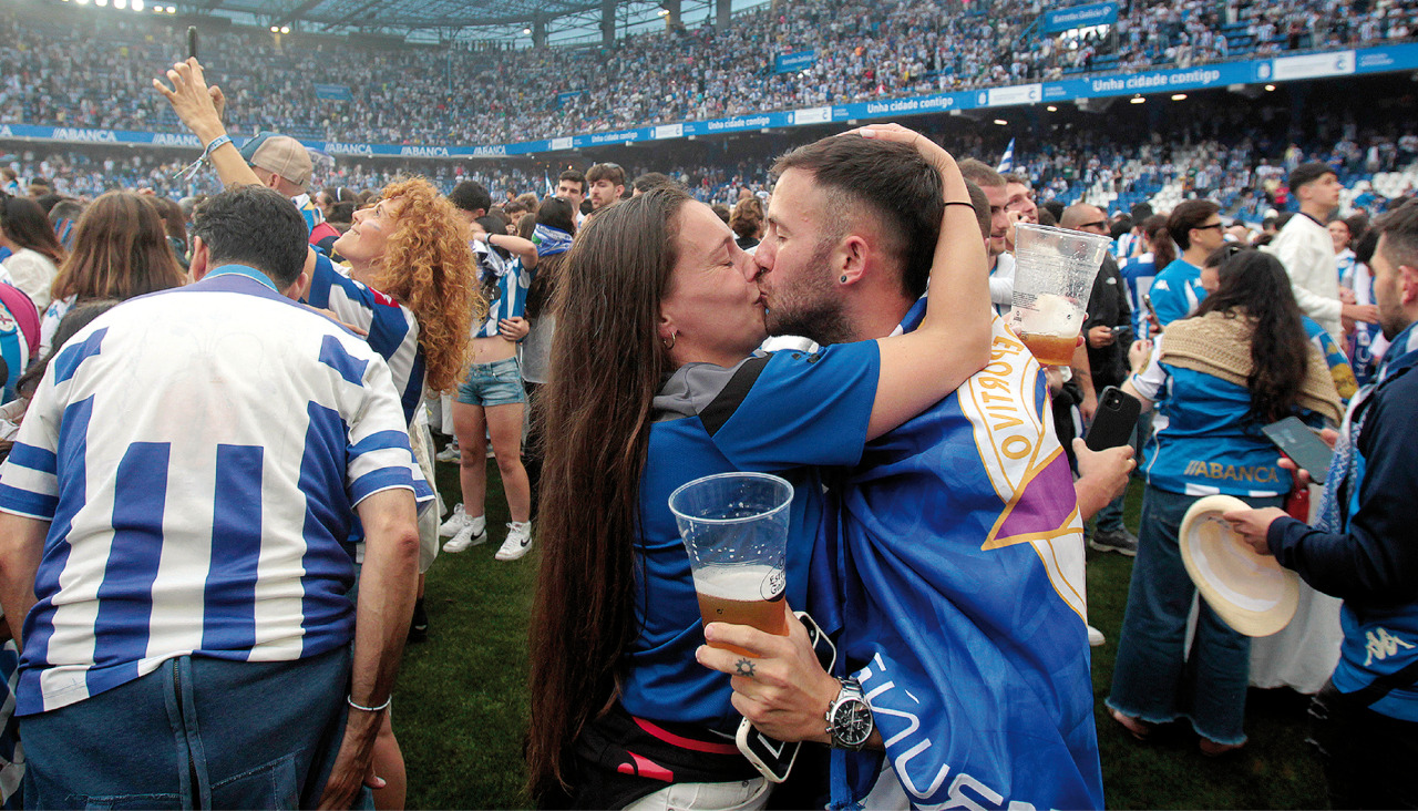 Una pareja de jóvenes se besa en pleno césped del municipal de Riazor durante la celebración del ascenso a Primera del Deportivo