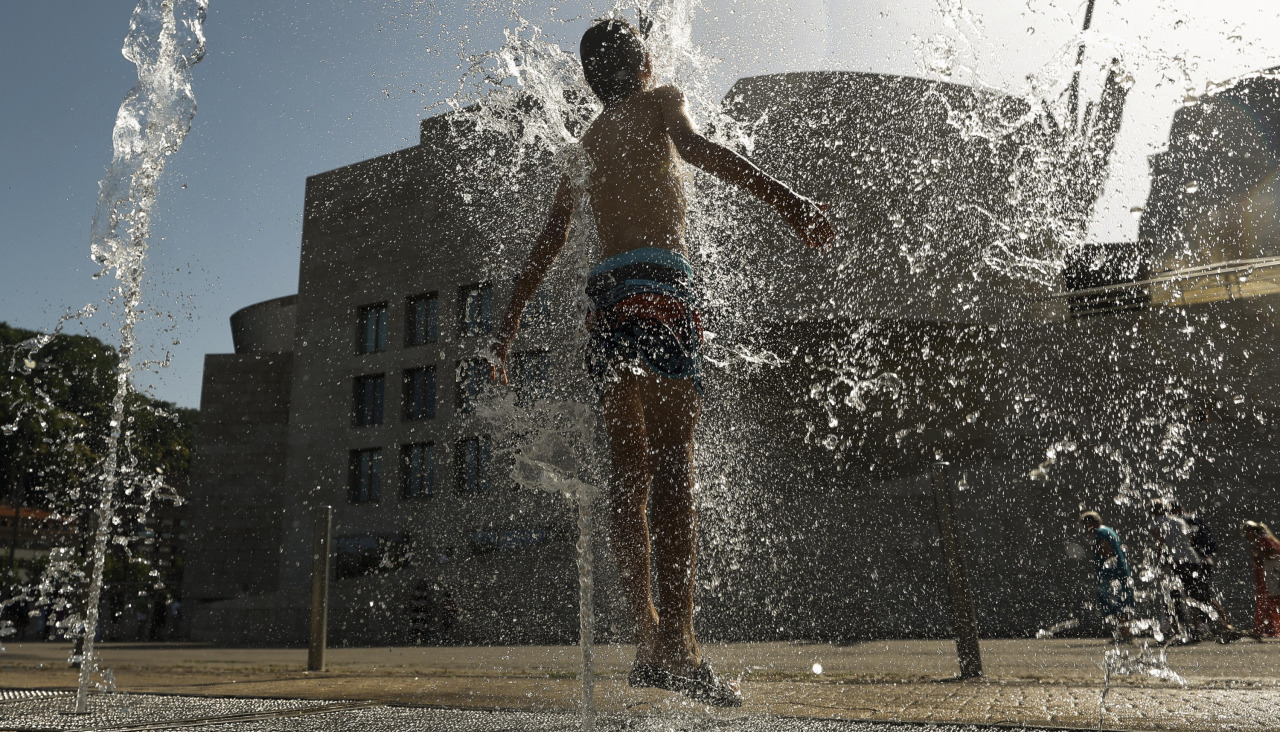 Un joven se refresca en una fuente, este martes, frente al Guggenheim de Bilbao