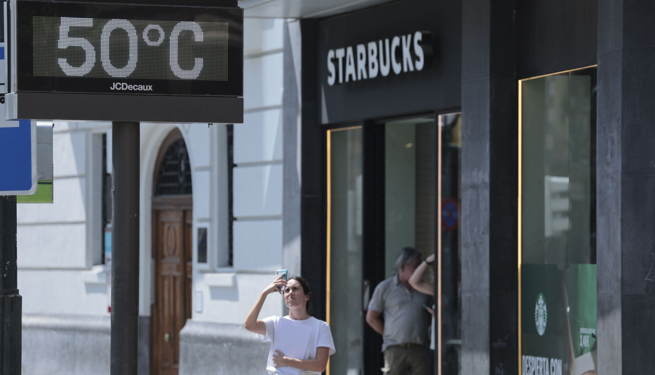 Una mujer fotografía la temperatura en un termómetro de Bilbao el 24 de junio