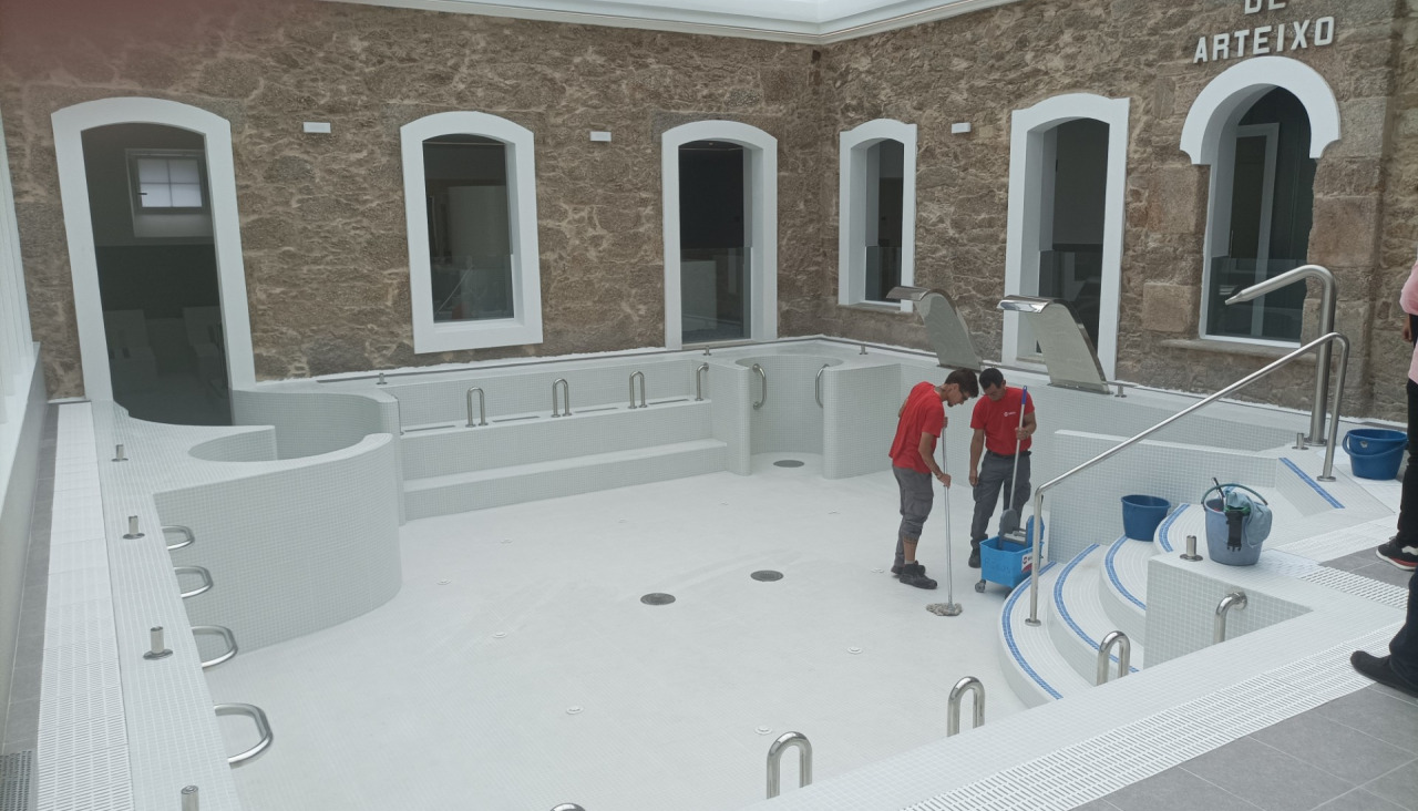 Dos operarios limpian la zona de baños