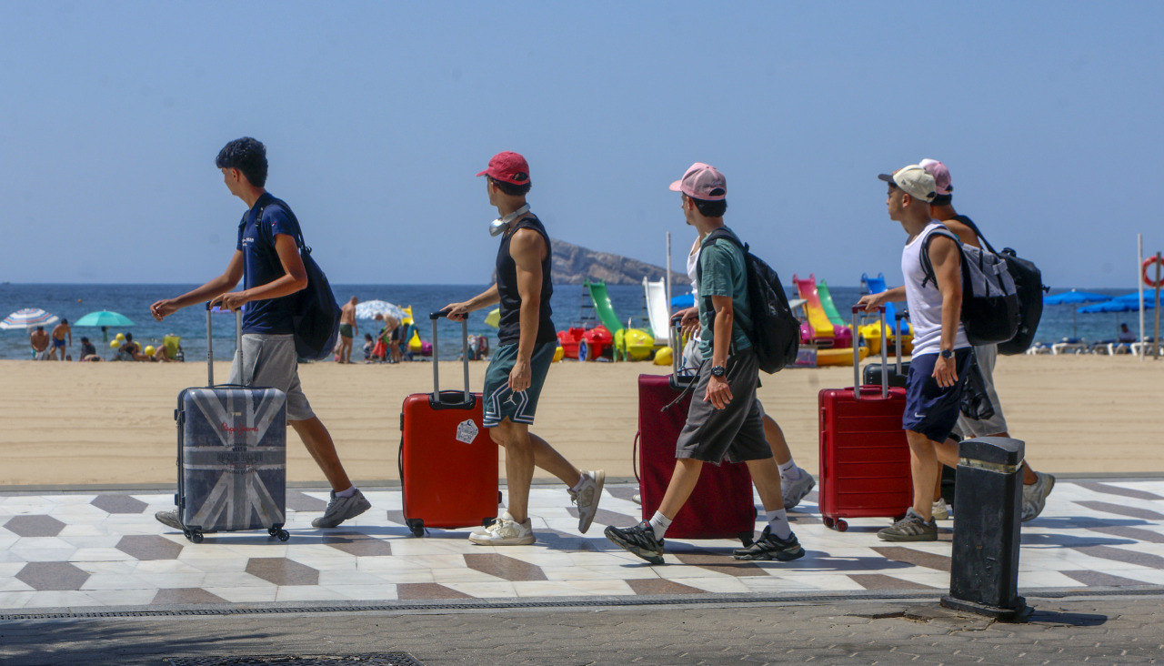 Unos turistas llegan a la playa de Benidorm