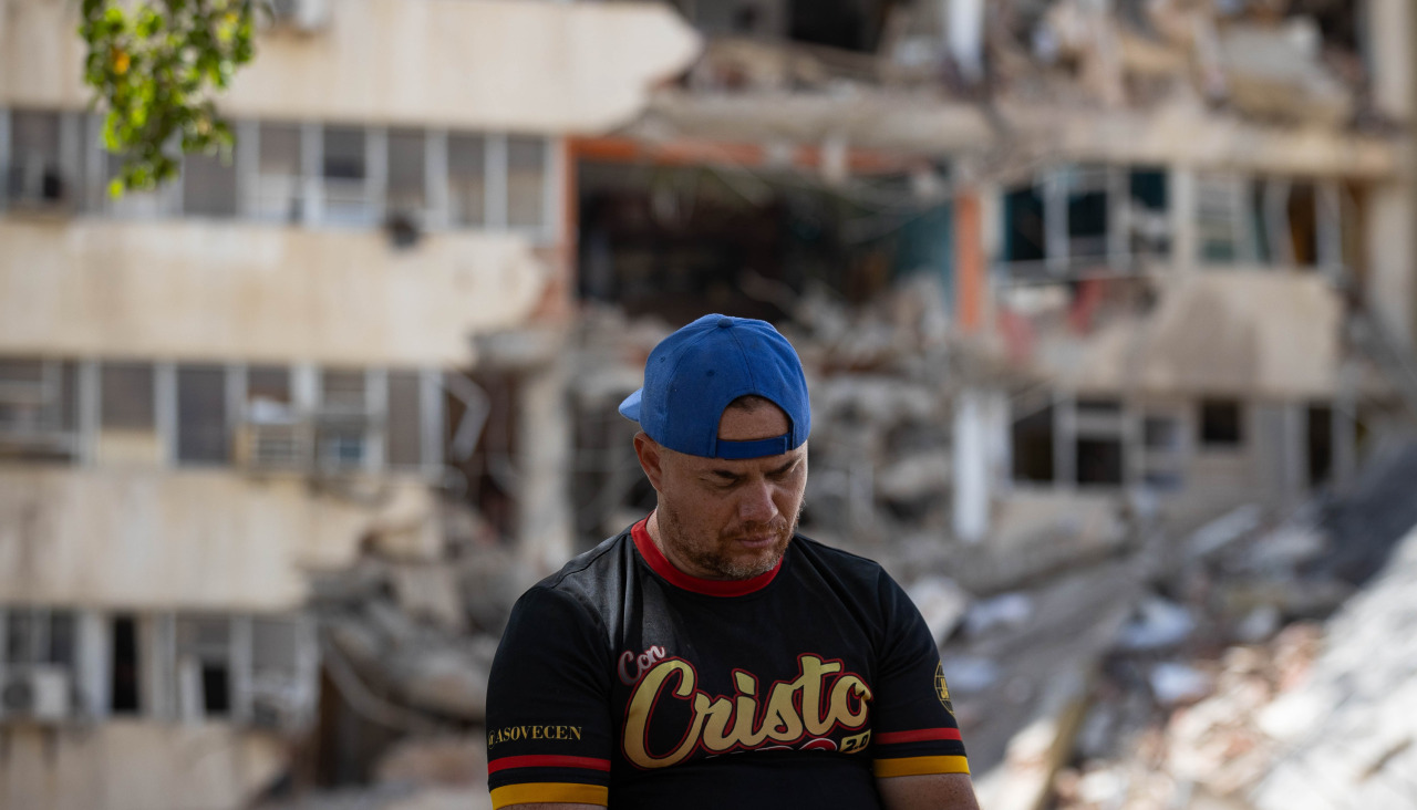 Un hombre reacciona junto a un edificio afectado por los terremotos