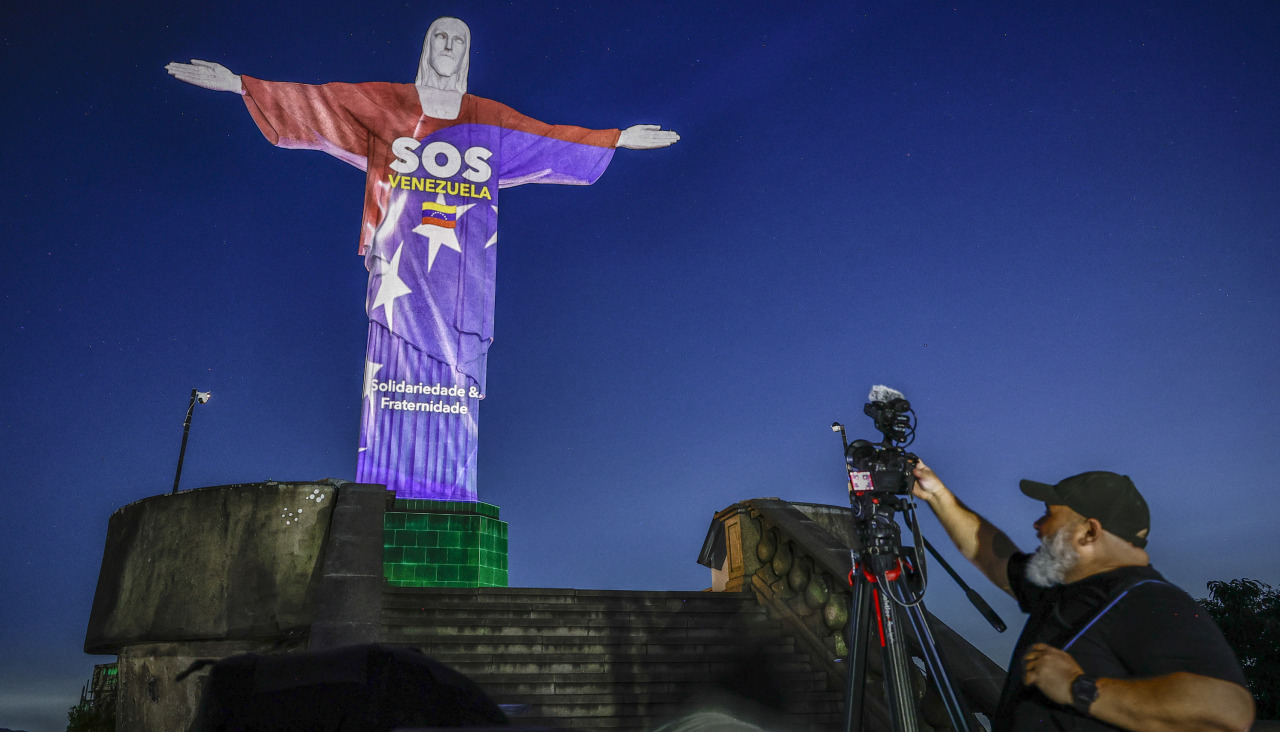 Una persona observa el monumento al Cristo Redentor, con una proyección en homenaje a las víctimas de los terremotos que azotaron a Venezuela
