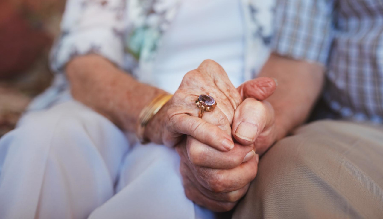 Dos personas mayores se toman de la mano