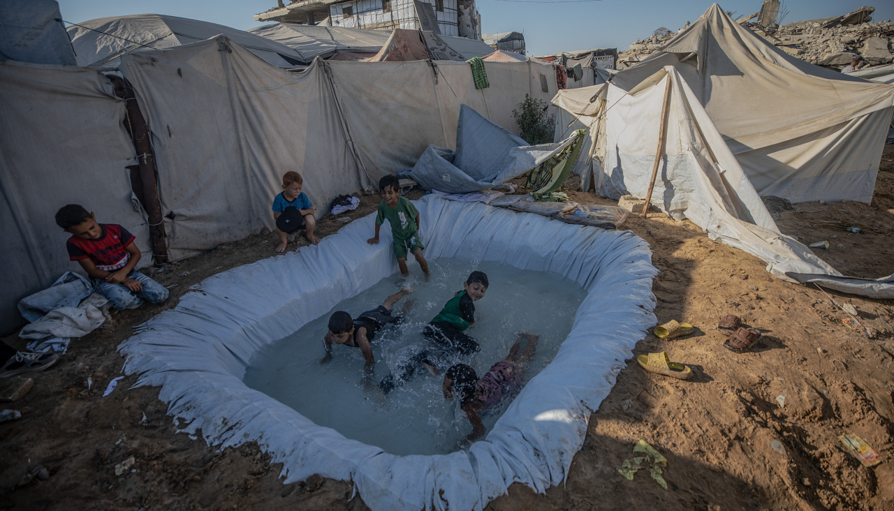 Niños refugiados de Gaza juegan en una piscina improvisada