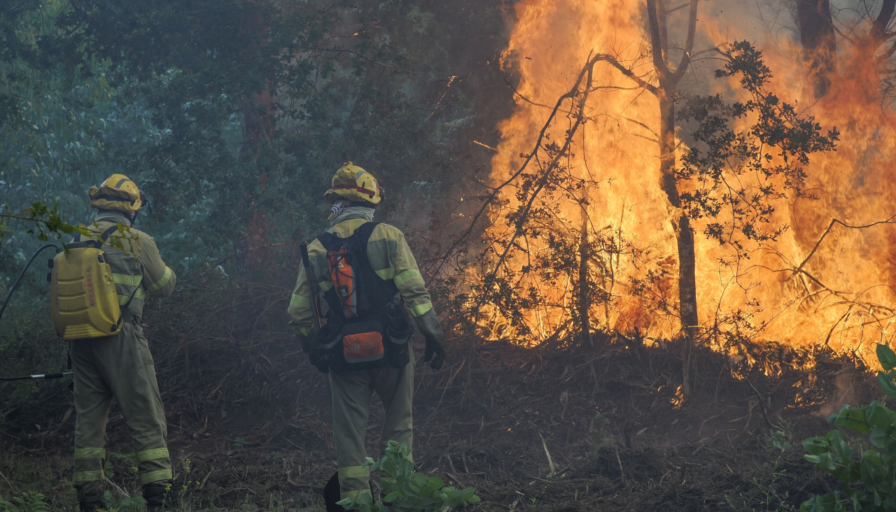 Dos bomberos trabajan en el incendio de Palas de Rei
