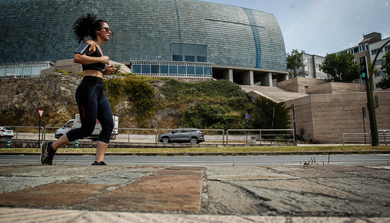 Una mujer corre por el Paseo Marítimo, a la altura de la Domus