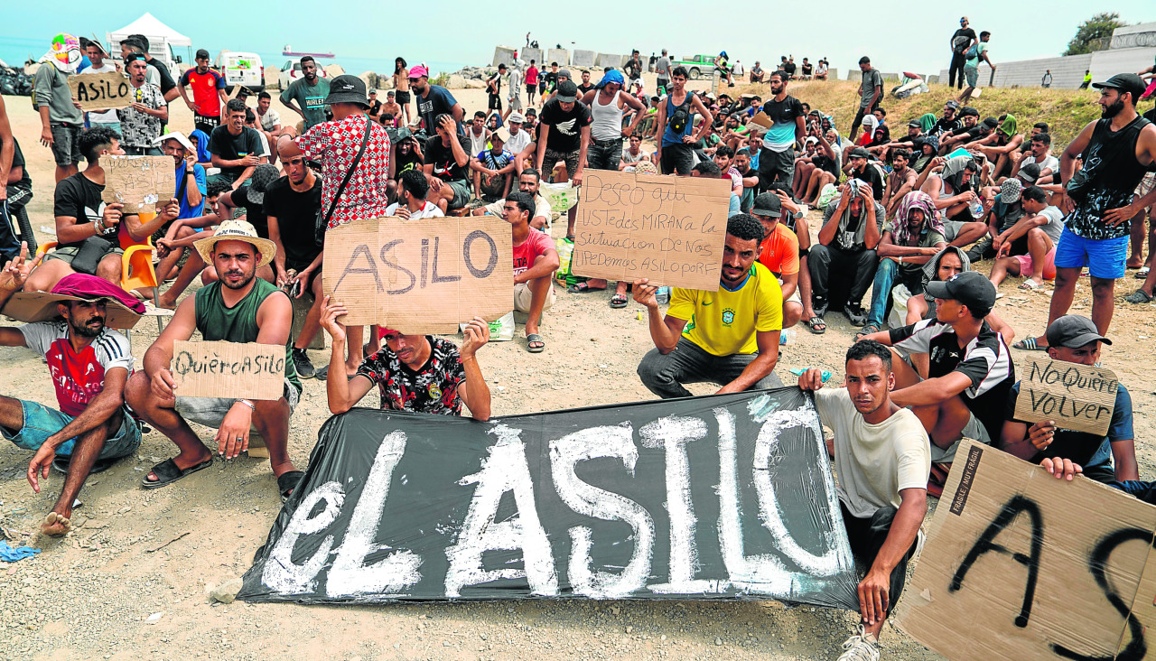 Un grupo de personas migrantes participa en una concentración para pedir asilo