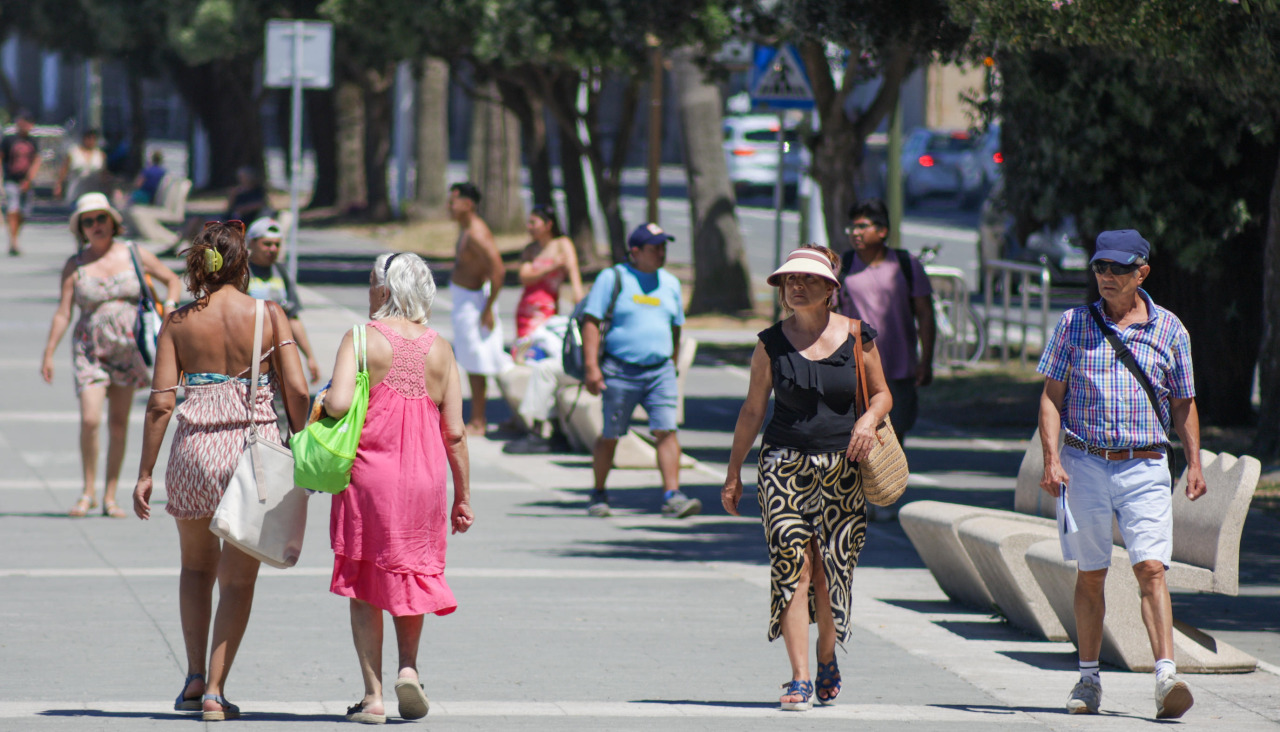 Viandantes transitan el Paseo Marítimo, en una de las jornadas más tórridas de este verano