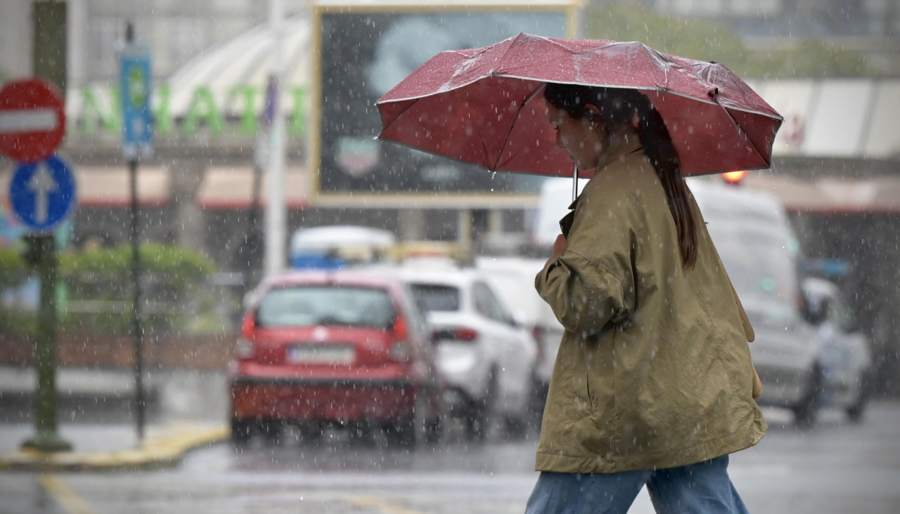 Una mujer bajo la lluvia este jueves en la plaza de Pontevedra