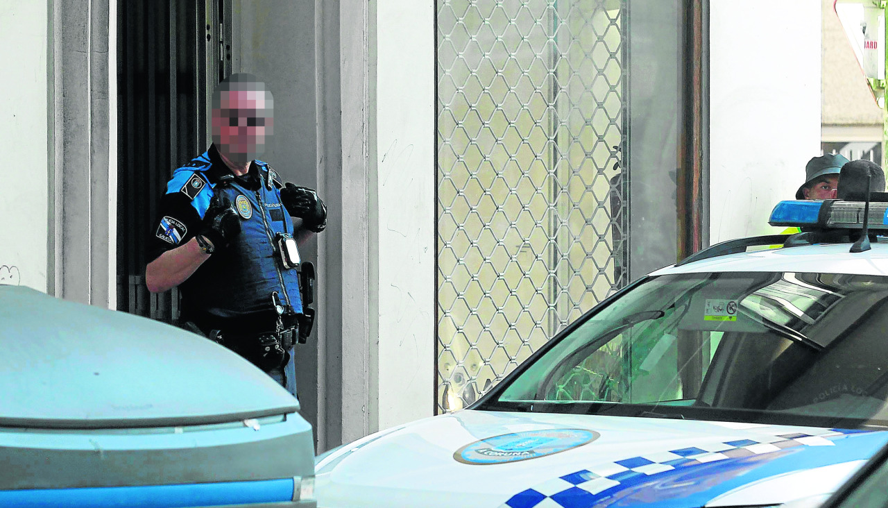 Un agente de la Policía Local sale de un domicilio privado en Os Mallos