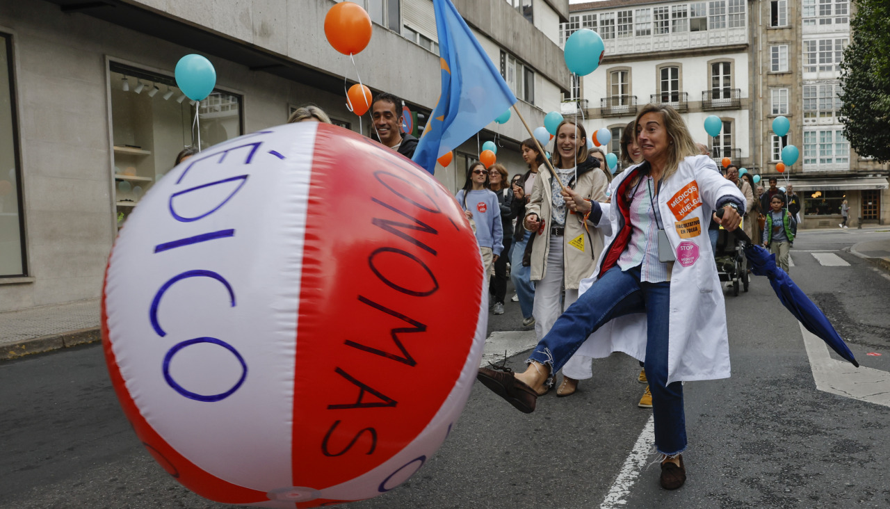 Una médico golpea un gran pelota de playa durante una manifestación de médicos