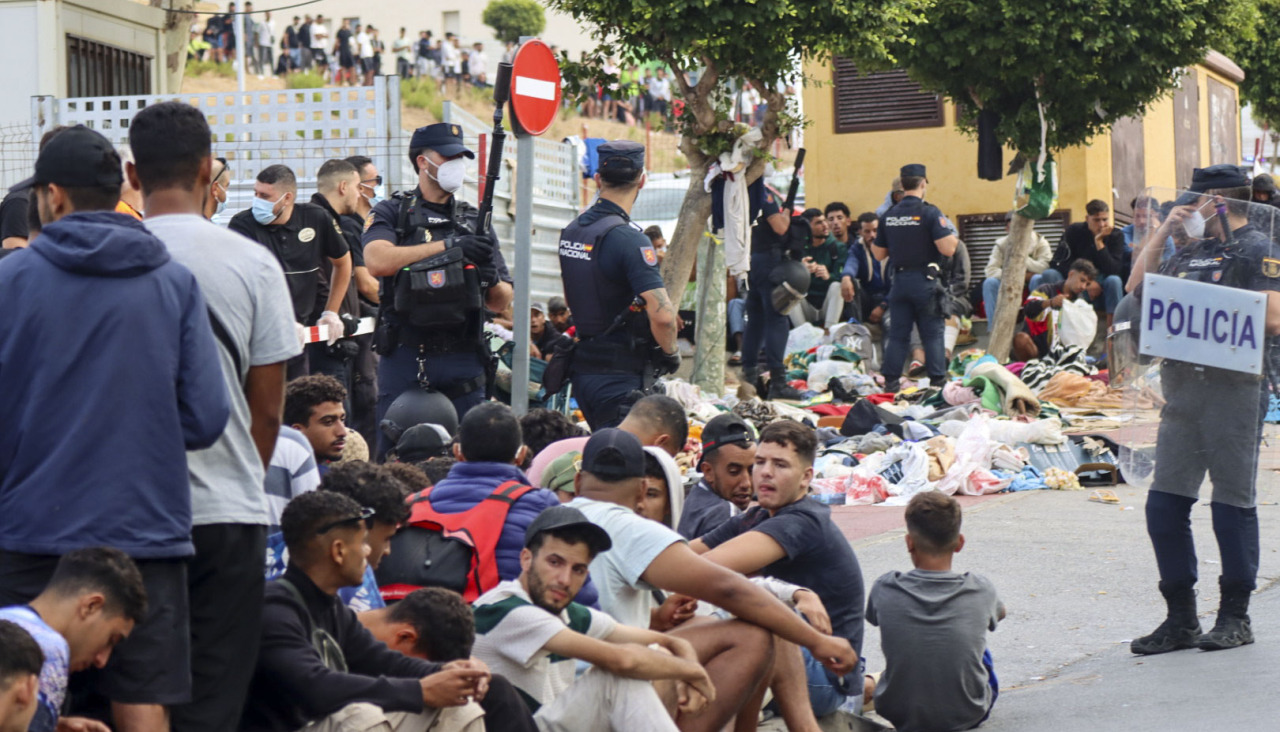 CEUTA, 31/08/2026.- Migrantes frente a la explanada de embotellamiento de Loma Colmenar donde hace casi dos semanas, se habilitó un campamento temporal para realojar a los migrantes pero de momento no es posible ya que no hay suficientes espacio para montar más carpas militares en la mencionada explanada. El Gobierno local de Ceuta y otros colectivos y organizaciones siguen reclamando la expulsión de los miles de migrantes que permanecen todavía en el territorio un mes después de la entrada de más de 70.000 personas a través de la frontera con Marruecos. EFE/Reduan