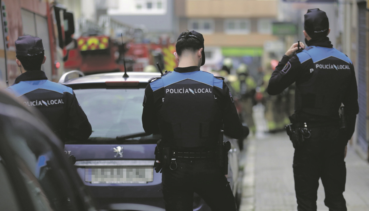 Agentes de la Policía Local con un coche aparcadoPolicÃas locales, durante una actuación